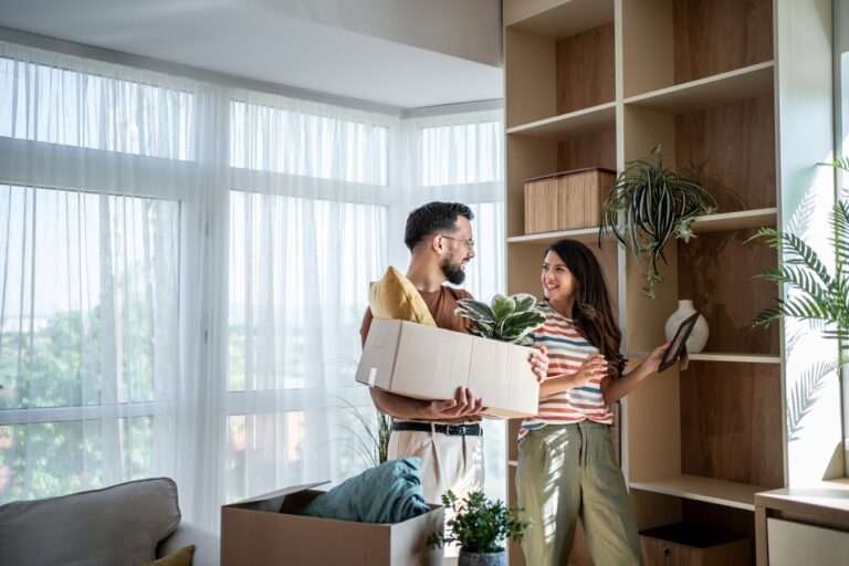Young,Smiling,Couple,Is,Unpacking,And,Arranging,Belongings,In,Their