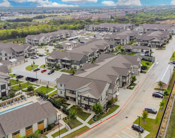 Aerial view of the property buildings at The Bradbury and the surrounding neighborhood area with surroundign greenery
