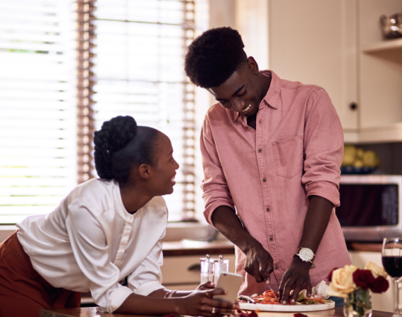 A man and a woman cooking together in a kitchen